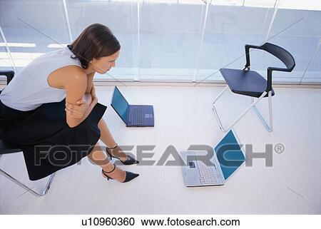 Businesswoman using laptop on floor View Large Photo Image Stock Image - Businesswoman using laptop on floor. Fotosearch