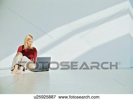 Businesswoman using laptop on floor View Large Photo Image Stock Photo - Businesswoman using laptop on floor. Fotosearch