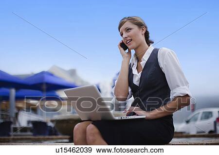 Businesswoman with laptop on cell phone View Large Photo Image Stock Photo - Businesswoman with laptop on cell phone. Fotosearch