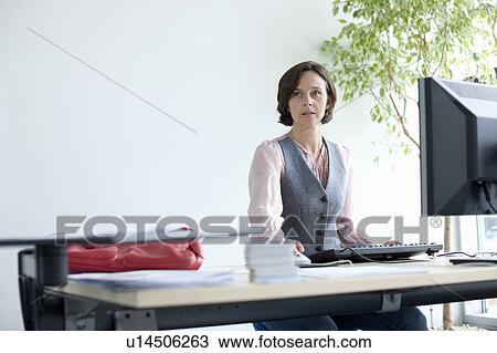Businesswoman working at desk View Large Photo Image Stock Image - Businesswoman working at desk. Fotosearch