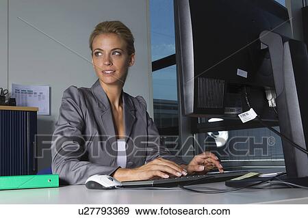 Businesswoman working at desk View Large Photo Image Stock Photo - Businesswoman working at desk. Fotosearch