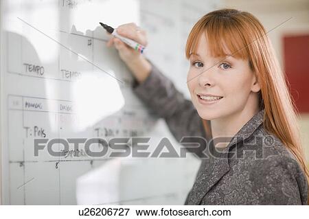 Businesswoman writing on calendar View Large Photo Image Stock Photo - Businesswoman writing on calendar. Fotosearch