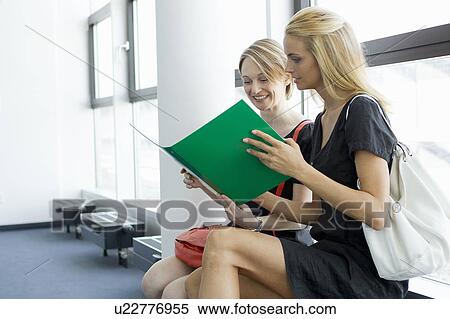 Stock Photography - Businesswomen reading in office. Fotosearch