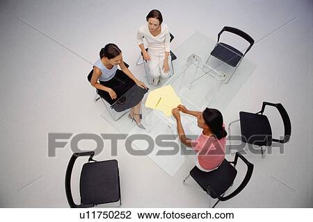 Stock Image - Businesswomen sitting in meeting. Fotosearch