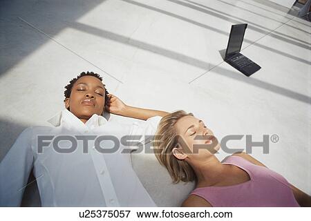 Businesswomen sleeping on floor View Large Photo Image Stock Photo - Businesswomen sleeping on floor. Fotosearch