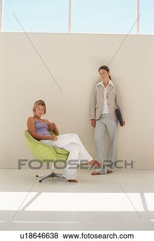 Businesswomen standing in office View Large Photo Image Stock Photo - Businesswomen standing in office. Fotosearch