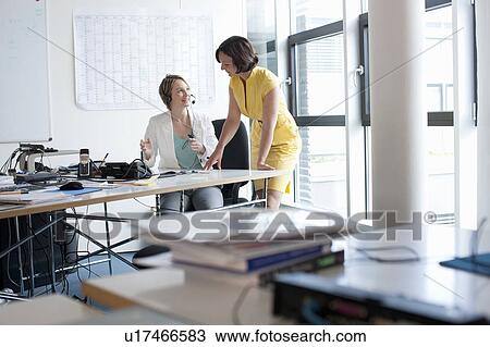 Businesswomen talking in office View Large Photo Image Stock Image - Businesswomen talking in office. Fotosearch