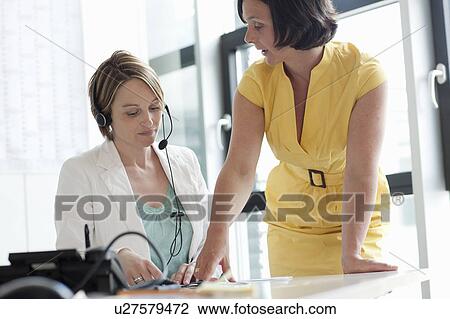 Stock Image - Businesswomen talking in office. Fotosearch