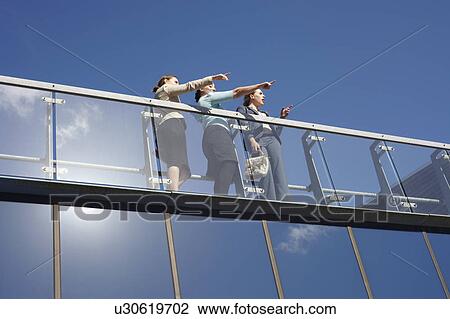 Stock Image - Businesswomen talking on walkway. Fotosearch