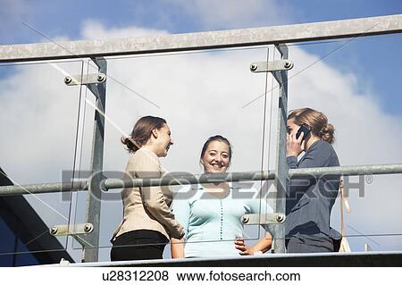 Stock Photo - Businesswomen talking on walkway. Fotosearch