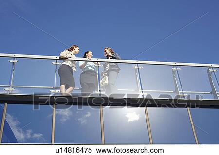 Stock Photography - Businesswomen talking on walkway. Fotosearch