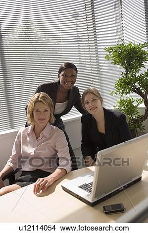 Businesswomen using laptop together View Large Photo Image Picture - Businesswomen using laptop together. Fotosearch