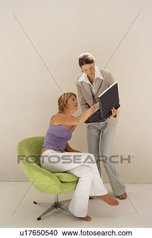 Businesswomen using laptop together View Large Photo Image Stock Image - Businesswomen using laptop together. Fotosearch