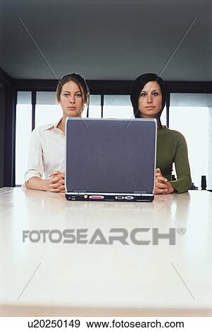 Businesswomen using laptop together View Large Photo Image Stock Photo - Businesswomen using laptop together. Fotosearch