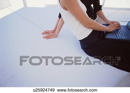 Stock Photo - Businesswomen using laptop together. Fotosearch