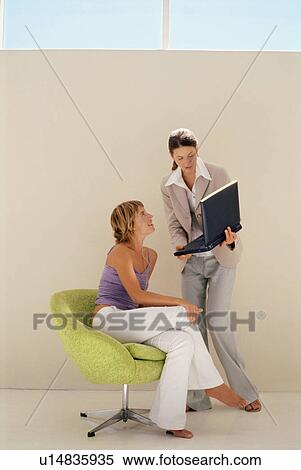 Businesswomen using laptop together View Large Photo Image Stock Photography - Businesswomen using laptop together. Fotosearch