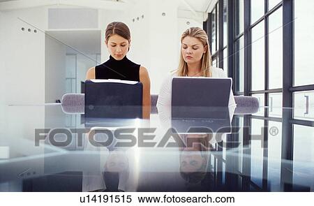 Businesswomen working on laptops View Large Photo Image Stock Photography - Businesswomen working on laptops. Fotosearch