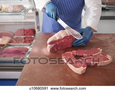Butcher carving beef joint into steaks View Large Photo Image Stock Image - Butcher carving beef joint into steaks. Fotosearch