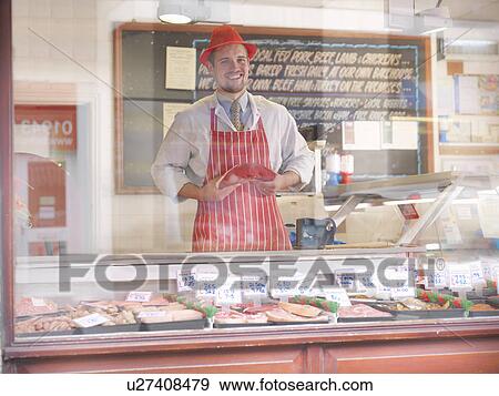 Butcher holding steak behind counter View Large Photo Image Stock Photo - Butcher holding steak behind counter. Fotosearch