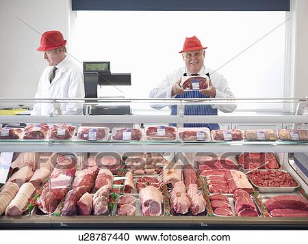 Butcher standing behind meat counter View Large Photo Image Stock Image - Butcher standing behind meat counter. Fotosearch