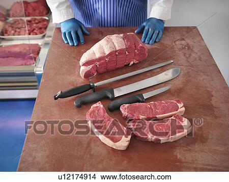 Butcher with knives and cuts of pork View Large Photo Image Picture - Butcher with knives and cuts of pork. Fotosearch
