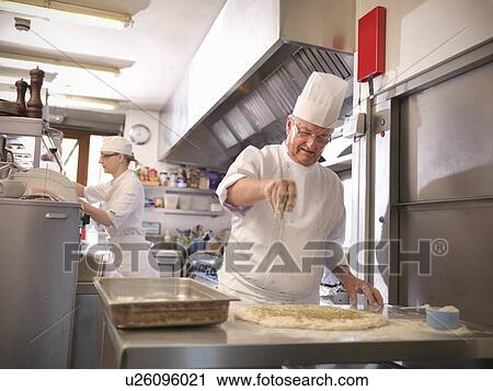 Stock Image - Chef making bread in restaurant kitchen. Fotosearch