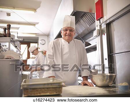 Stock Image - Chef smiling in restaurant kitchen. Fotosearch