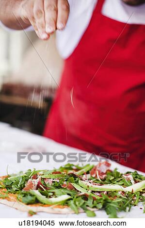 Chef sprinkling spices over pizza View Large Photo Image Stock Photography - Chef sprinkling spices over pizza. Fotosearch