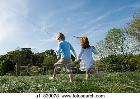 Children holding hands in field View Large Photo Image Stock Photo - Children holding hands in field. Fotosearch