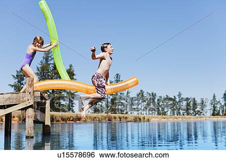 Children jumping into lake from jetty View Large Photo Image Stock Photograph - Children jumping into lake from jetty. Fotosearch