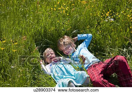 Children laying in field of flowers View Large Photo Image Picture - Children laying in field of flowers. Fotosearch