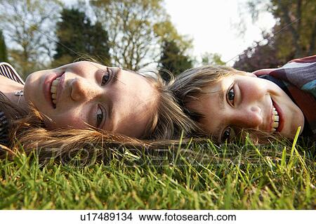 Children laying in grass together View Large Photo Image Picture - Children laying in grass together. Fotosearch