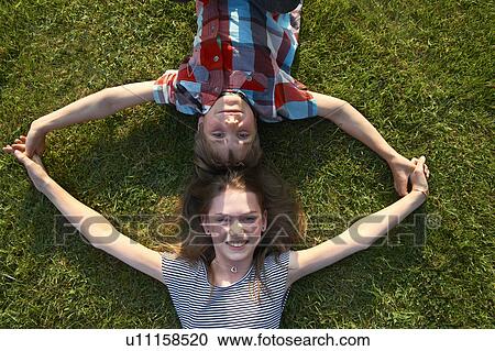 Children laying in grass together View Large Photo Image Stock Image - Children laying in grass together. Fotosearch