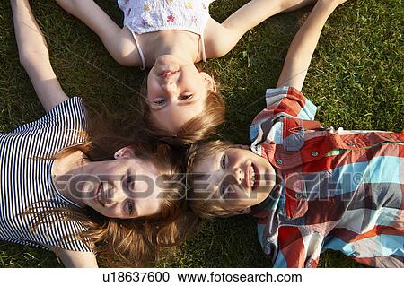 Children laying in grass together View Large Photo Image Stock Image - Children laying in grass together. Fotosearch
