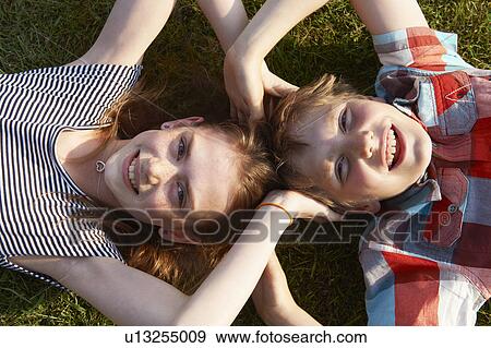 Children laying in grass together View Large Photo Image Stock Photo - Children laying in grass together. Fotosearch