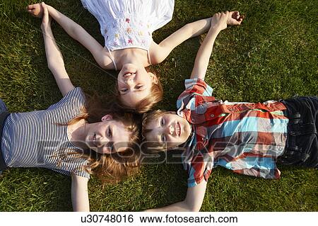 Children laying in grass together View Large Photo Image Stock Photograph - Children laying in grass together. Fotosearch