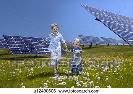 Stock Photograph - Children playing near solar panels. Fotosearch