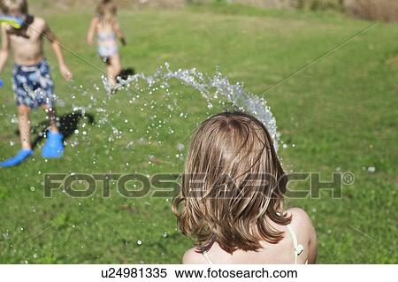 Children playing with hose in backyard View Large Photo Image Stock Photography - Children playing with hose in backyard. Fotosearch
