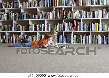 Children reading together by bookshelves View Large Photo Image Stock Image - Children reading together by bookshelves. Fotosearch