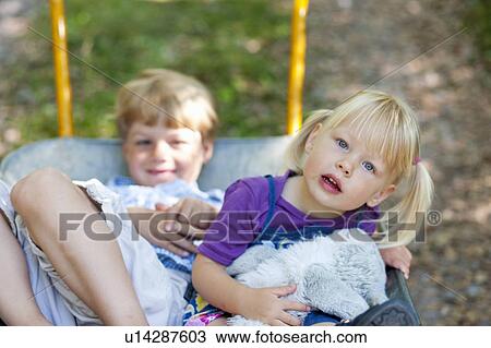 Children sitting in wheelbarrow View Large Photo Image Stock Image - Children sitting in wheelbarrow. Fotosearch
