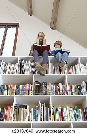 Children sitting on top of bookshelves View Large Photo Image Stock Image - Children sitting on top of bookshelves. Fotosearch