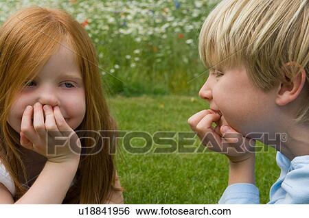Stock Photograph - Children talking in field of flowers. Fotosearch