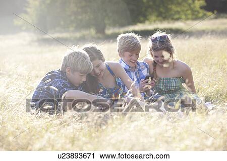 Children using cell phones in field View Large Photo Image Stock Image - Children using cell phones in field. Fotosearch