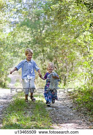 Children walking hand-in-hand outdoors View Large Photo Image Stock Photo - Children walking hand-in-hand outdoors. Fotosearch