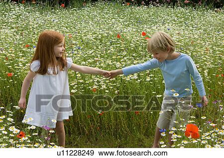 Stock Photo - Children walking in field of flowers. Fotosearch