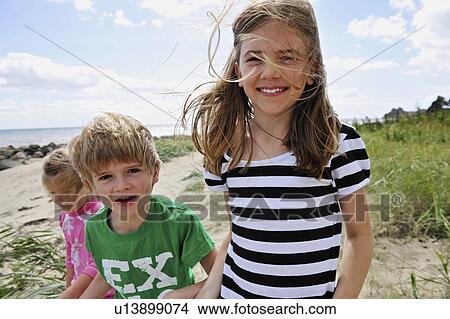 Children walking on beach together View Large Photo Image Picture - Children walking on beach together. Fotosearch