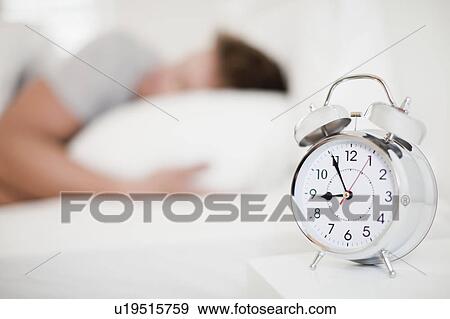 Stock Photo - Close up of alarm clock on bedside table. Fotosearch