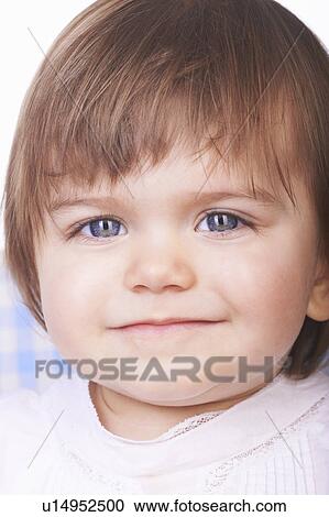 Stock Image - Close up of baby girl’s smiling face. Fotosearch