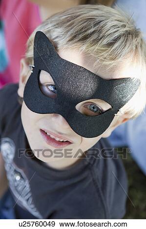 Stock Photo - Close up of boy wearing cat mask. Fotosearch