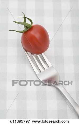 Close up of cherry tomato on fork View Large Photo Image Stock Photo - Close up of cherry tomato on fork. Fotosearch